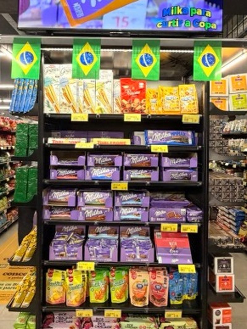 Tela LED com anúncio da Milka logo acima da ponta de gôndola da mesma marca